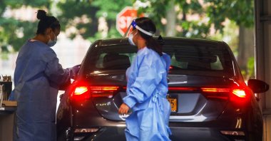 Staff members attend to a person receiving the monkeypox vaccine at a drive-through monkeypox vaccination point at the Westchester Medical Center in Valhalla, New York, U.S., July 28, 2022. (Reuters Photo)