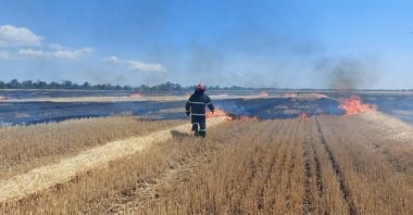A firefighter works in a field, which burns after a military strike, as Russia's attack on Ukraine continues, in the Mykolaiv region, Ukraine, July 27, 2022. (Reuters Photo)