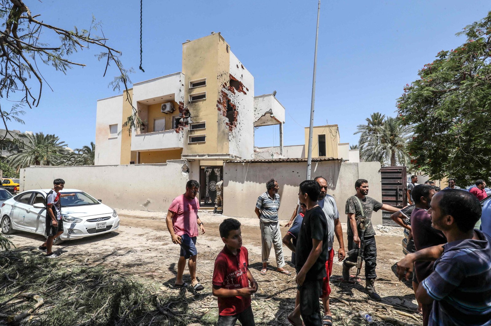 People assess the damage caused by recent fighting between armed groups in a neighborhood of the capital Tripoli, Libya, July 23, 2022. (AFP Photo)