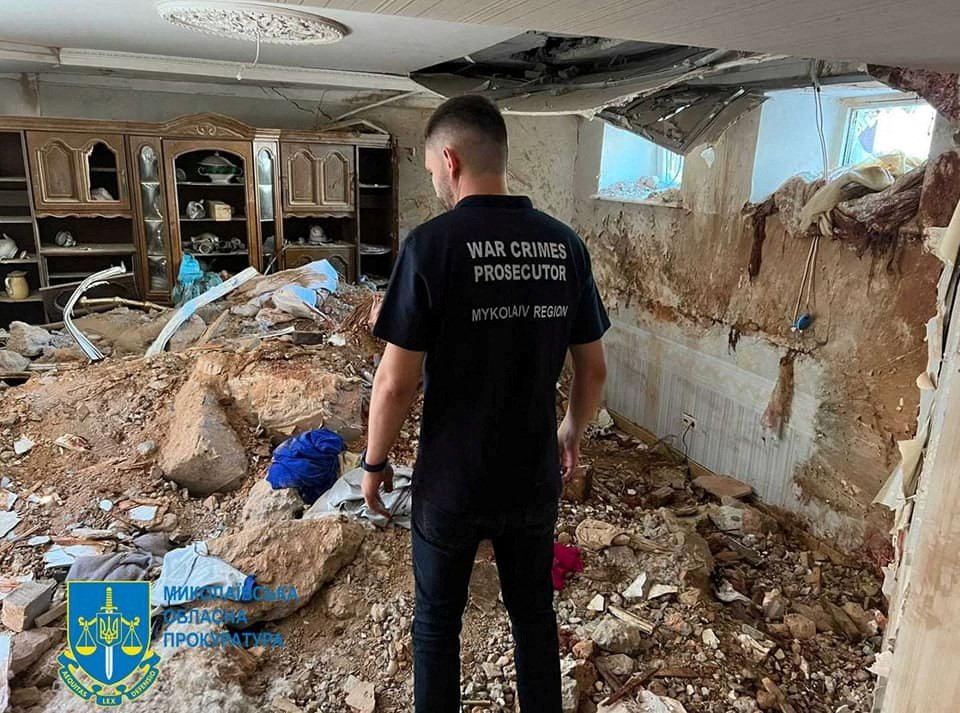 A war crimes prosecutor examines the damage in a destroyed building, following shelling in Mykolaiv, Ukraine, July 31, 2022.  (Press service of the Mykolaiv Regional Prosecutor&#039;s Office via Reuters)