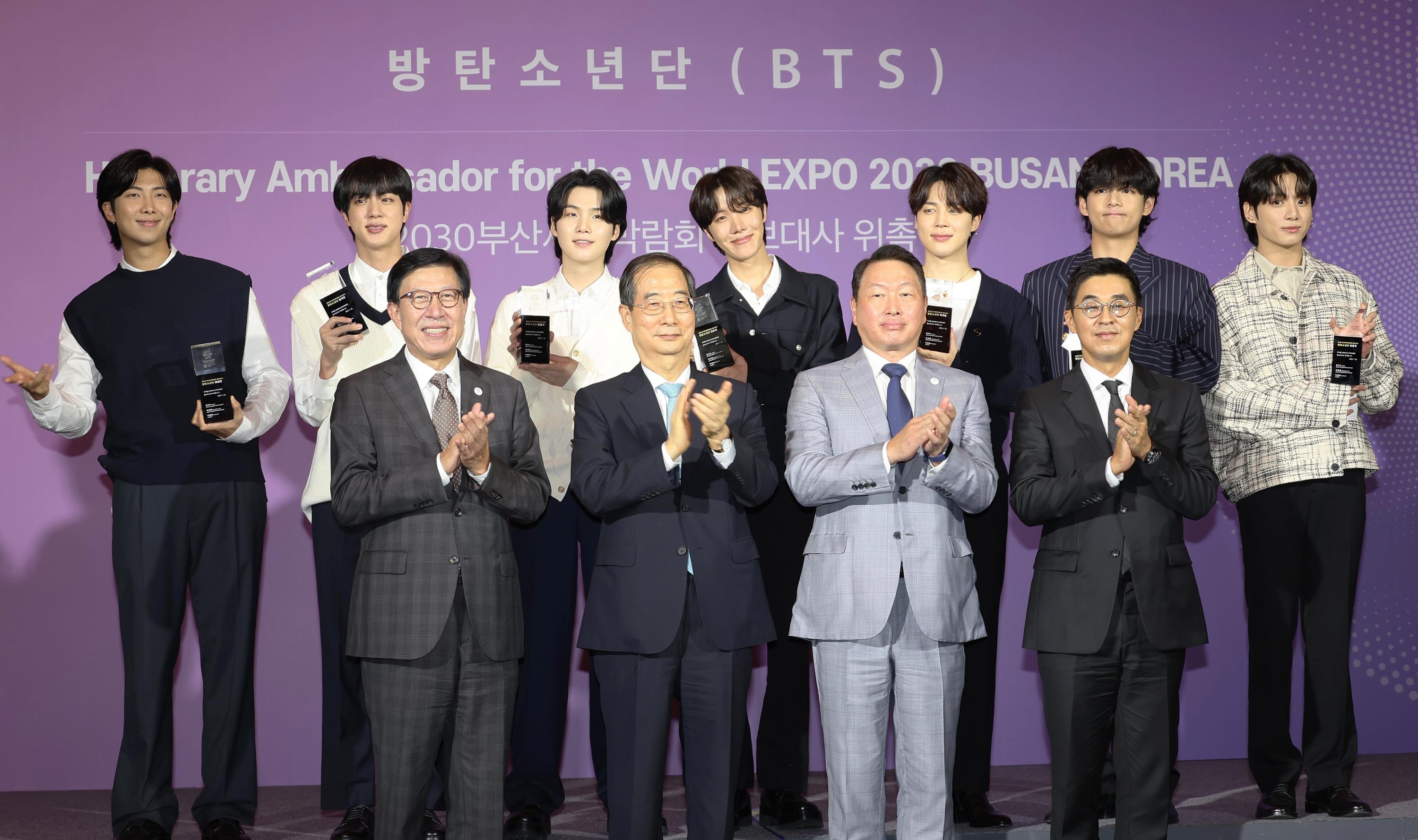 Perdana Menteri Korea Selatan Han Duck-soo (2-L, barisan depan) berfoto dengan anggota grup K-pop BTS (baris belakang) selama upacara penunjukan septet sebagai duta promosi untuk menjadi tuan rumah Expo Dunia 2030 di kota pelabuhan selatan Busan, di Hybe di Seoul, 19 Juli 2022. (EPA)
