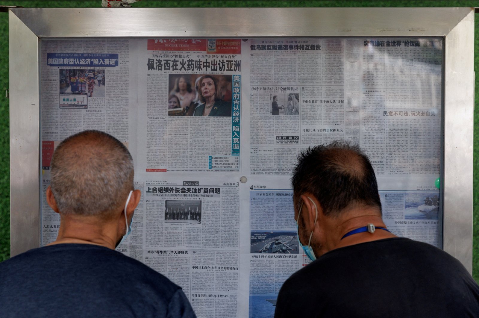 Men read the Global Times newspaper that features a front page article about U.S. House of Representatives Speaker Nancy Pelosi&#039;s Asia tour at a street display wall in Beijing, China, Aug. 1, 2022. The front page headline reads: &quot;Pelosi visits Asia in the smell of gunpowder.&quot; (Reuters Photo)