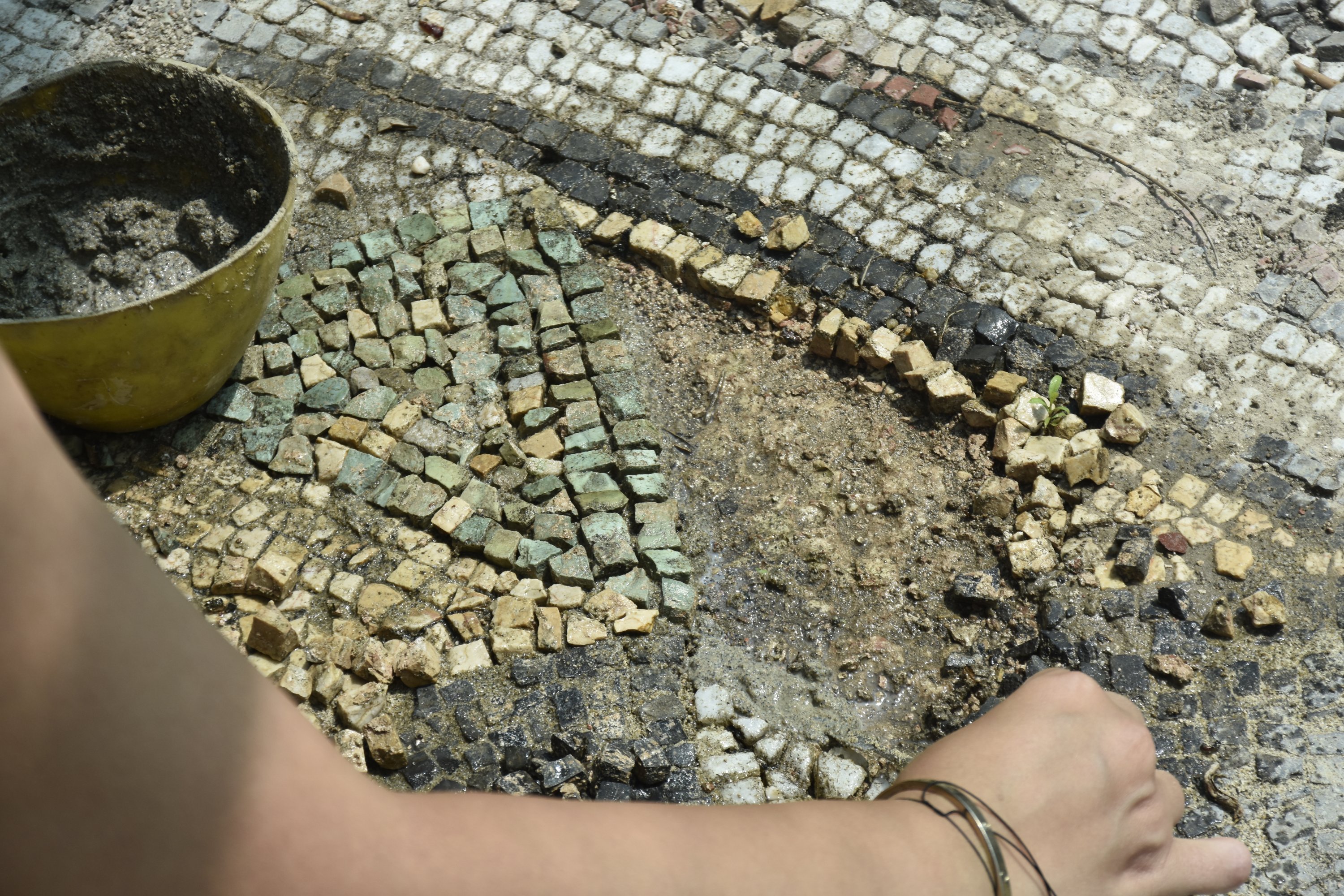Seorang ahli mengerjakan mosaik di kota kuno Myrleia, Bursa, Turki barat laut, 1 Agustus 2022. (AA) 