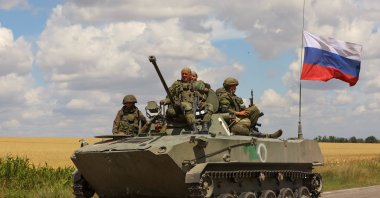 Service members of Russian troops ride on top an armored vehicle in the Russian-held part of the Zaporizhzhia region, Ukraine, July 23, 2022. (Reuters Photo)