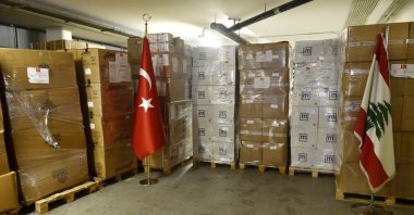 Lebanese and Turkish flags stand against a backdrop of the boxes containing aid, in Beirut, Lebanon, Aug. 2, 2022. (AA PHOTO) 