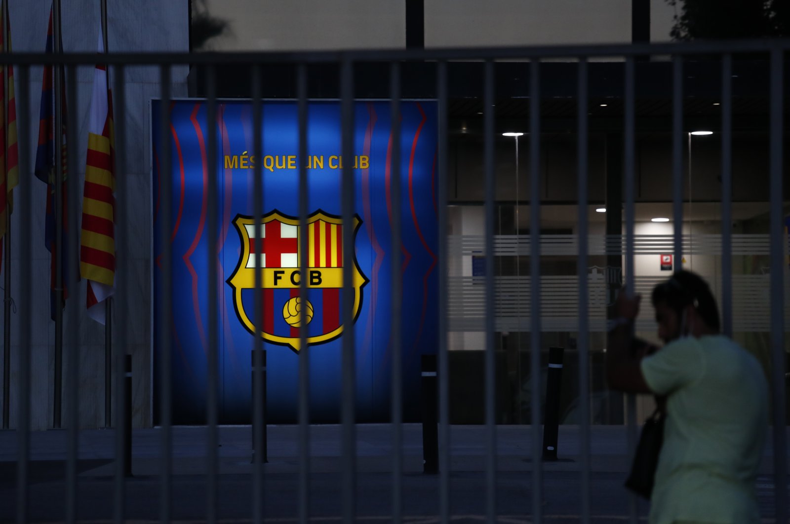 A fan peers through the railings of the entrance of Barcelona&#039;s offices at the Camp Nou stadium in Barcelona, Spain, Aug. 5, 2021. (AP Photo)