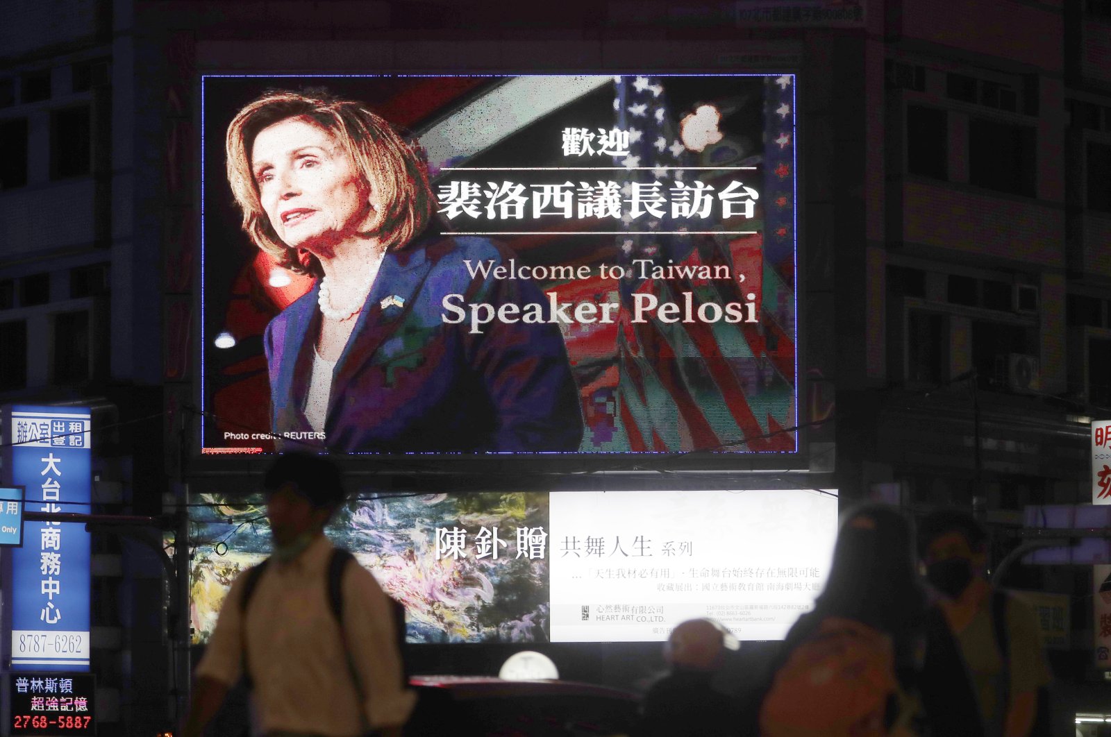 People walk past a billboard welcoming U.S. House Speaker Nancy Pelosi, in Taipei, Taiwan, Aug 2, 2022. (AP Photo)