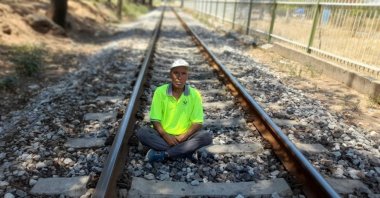 Mehmet Erbil sits on the tracks, in Manisa, western Turkey, Aug. 2, 2022. (PHOTO BY FATMA DAMLA KAYAYERLİ) 