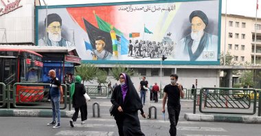 Iranians walk past a billboard displaying Iran&#039;s Supreme Leader Ayatollah Ali Khamenei and Ayatollah Ruhollah Khomeini in the capital Tehran, Iran, July 31 2022. (AFP Photo)