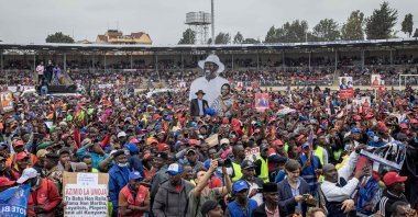 Azimio La Umoja (One Kenya Coalition Party) supporters wave a cardboard cutout with a picture of presidential candidate Raila Odinga and running mate Martha Karua during a campaign rally in Kirigiti Stadium, Kiambu, Kenya, Aug. 1, 2022. (AFP Photo)