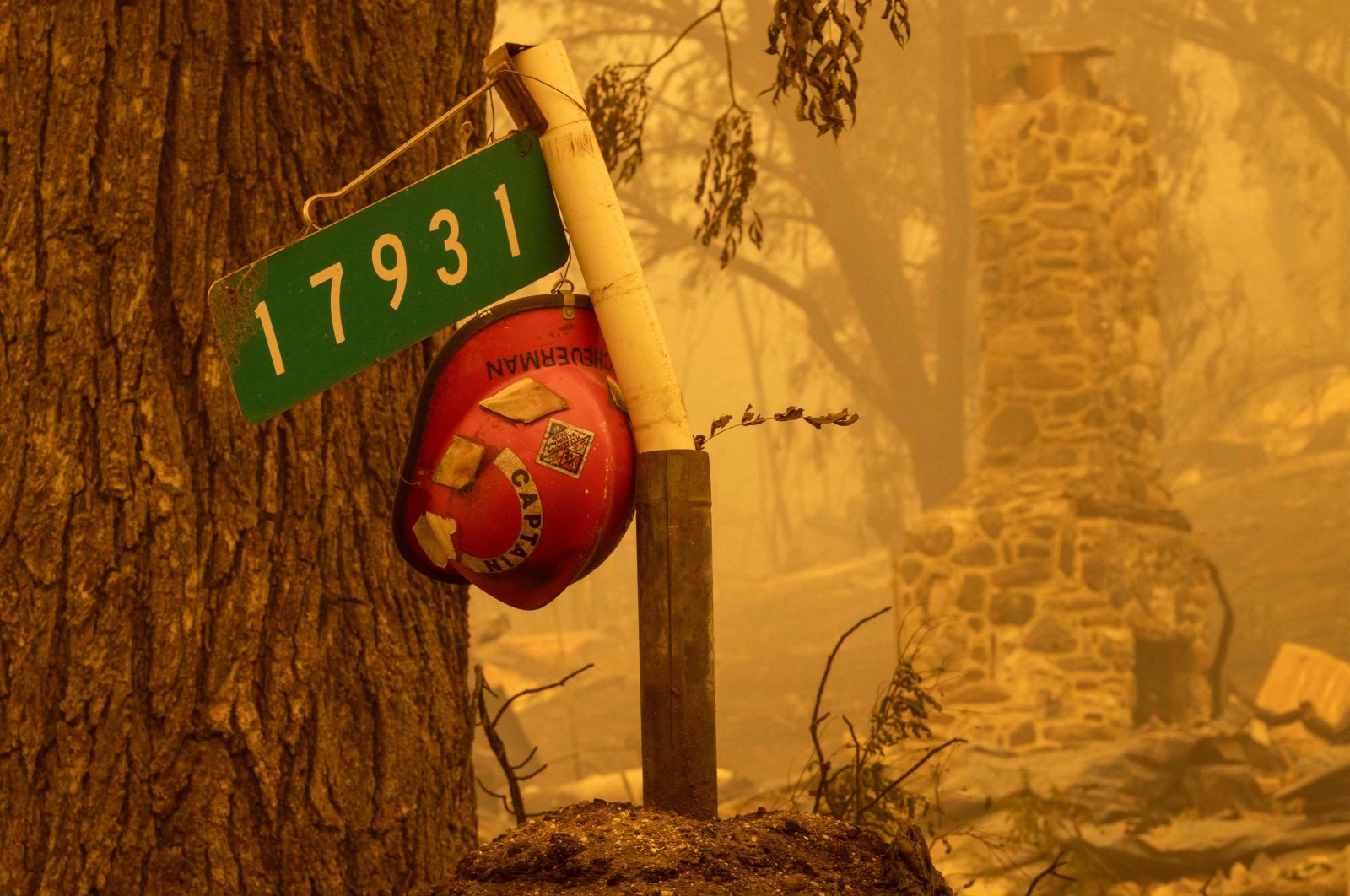 A firefighter helmet hangs at the entrance to a property in the community of Klamath River that burned down, in Klamath National Forest, northwest of Yreka, California, U.S., July 31, 2022. (AFP Photo)