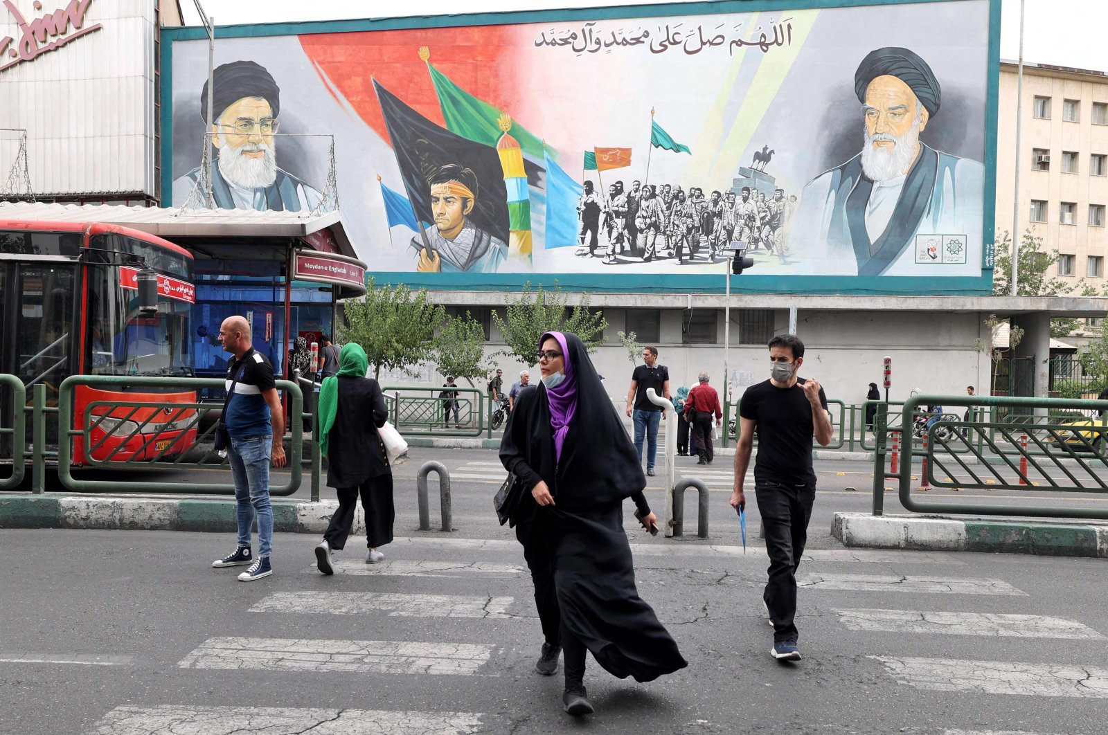 Iranians walk past a billboard displaying Iran&#039;s Supreme Leader Ayatollah Ali Khamenei and Ayatollah Ruhollah Khomeini in the capital Tehran, Iran, July 31 2022. (AFP Photo)