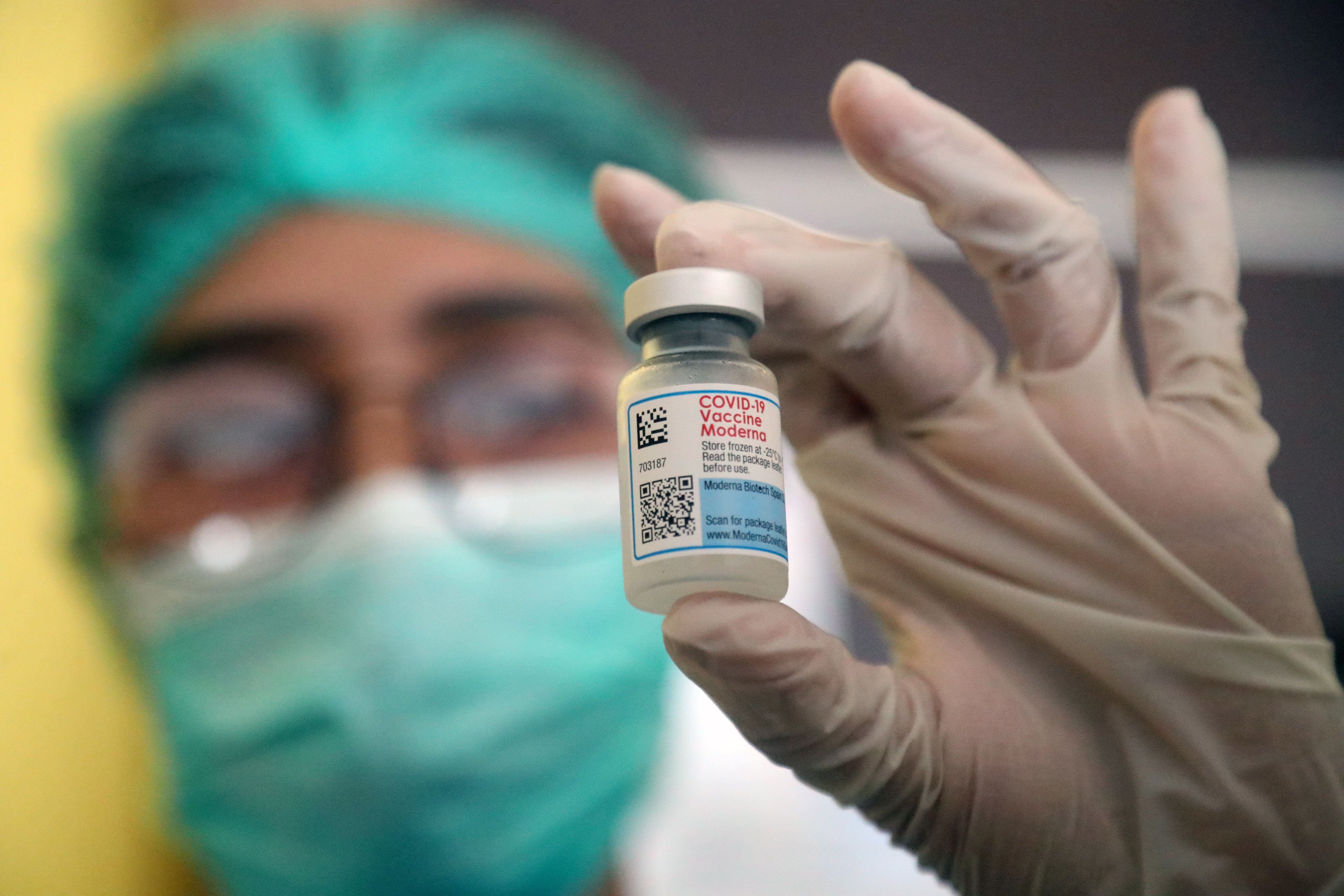 An Indonesian health worker displays a Moderna vaccine vial before administering a dose to her coworkers during a COVID-19 booster vaccination drive in Jakarta, Indonesia, Aug. 2 2022. (EPA PHOTO)