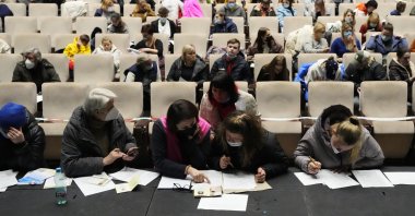 Refugees that fled the war in Ukraine fill in the paperwork to get registered, at the congress center in Prague, Czech Republic, March 15, 2022. (AP Photo) 