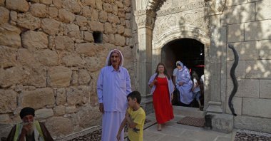 Iraqi Yazidis gather during a religious ceremony at the Lalish temple in a valley near the city of Dohuk, in northern Iraq, on August 1, 2022. (Photo by SAFIN HAMED / AFP)