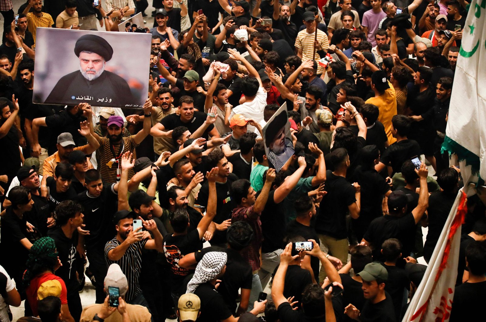 Supporters of Iraqi cleric Muqtada Sadr (image) wave flags as they occupy the Iraqi parliament for a fifth consecutive day, in protest at a nomination for prime minister by a rival Shiite faction, in the capital Baghdad&#039;s high-security Green Zone, Iraq, Aug. 3, 2022. (AFP Photo)