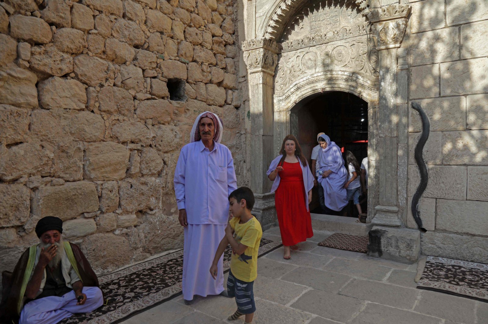 Iraqi Yazidis gather during a religious ceremony at the Lalish temple in a valley near the city of Dohuk, in northern Iraq, on August 1, 2022. (Photo by SAFIN HAMED / AFP)