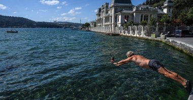 A swimmer dives into the water in the Bebek neighborhood, in Istanbul, Turkey, July 29, 2022. (AFP PHOTO)