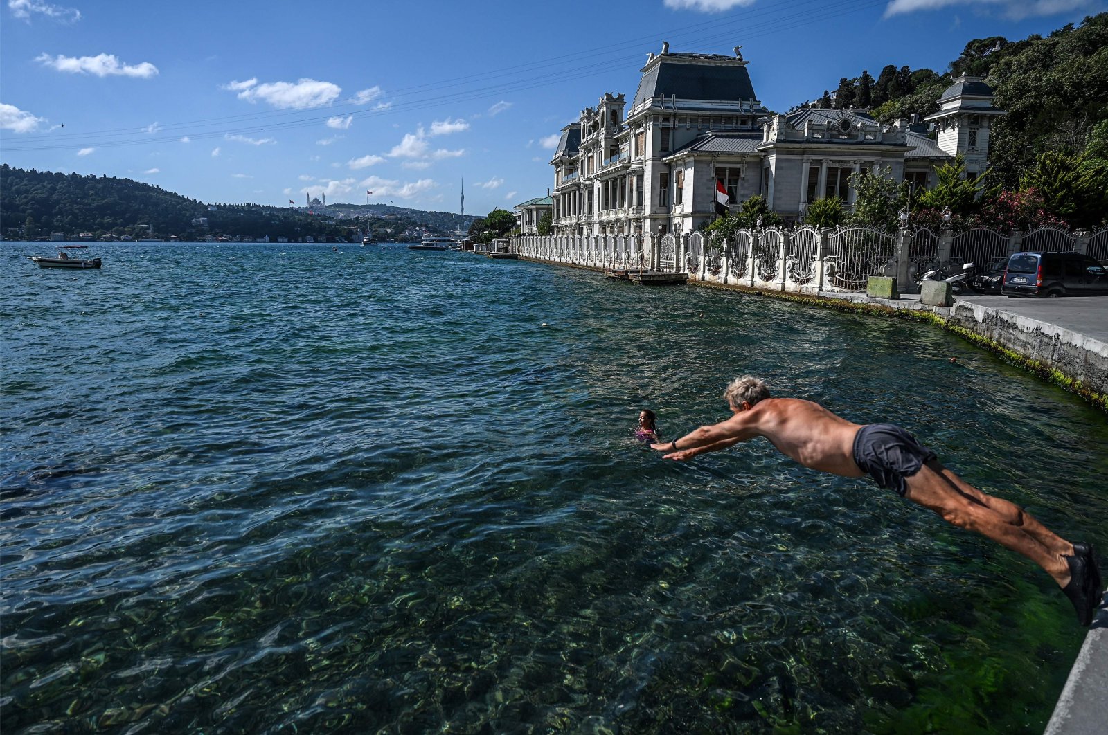 A swimmer dives into the water in the Bebek neighborhood, in Istanbul, Turkey, July 29, 2022. (AFP PHOTO)