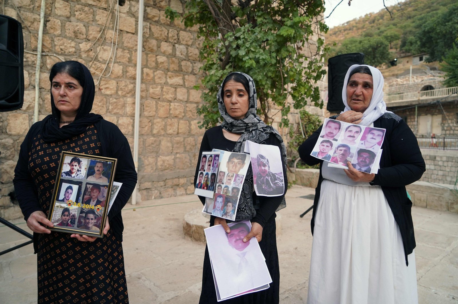 Women members of Iraq&#039;s Yazidi community hold photos of victims of the August 2014 massacre carried out in the Sinjar region by Daesh during a commemoration of the eighth anniversary of the event at the Temple of Lalish, in Dohuk, Iraq, Aug. 2, 2022. (AFP Photo)
