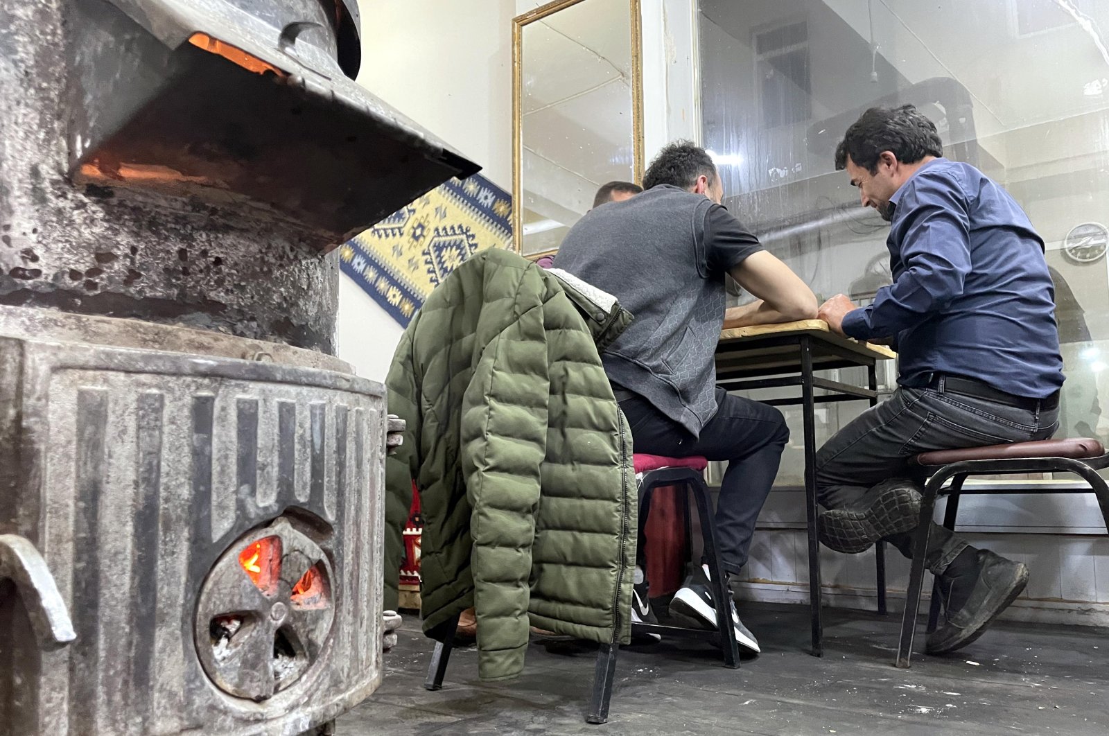 People sit next to a stove in a coffeehouse, in Ardahan, northeastern Turkey, Aug. 5, 2022. (AA PHOTO)