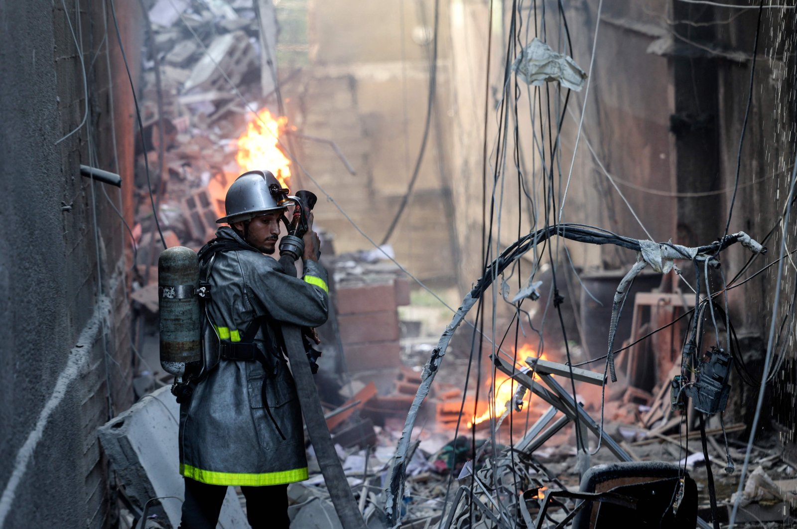 A Palestinian firefighter tackles the blaze amid the destruction following an Israeli air strike on Gaza City, Palestine, Aug. 5, 2022. (AFP Photo)