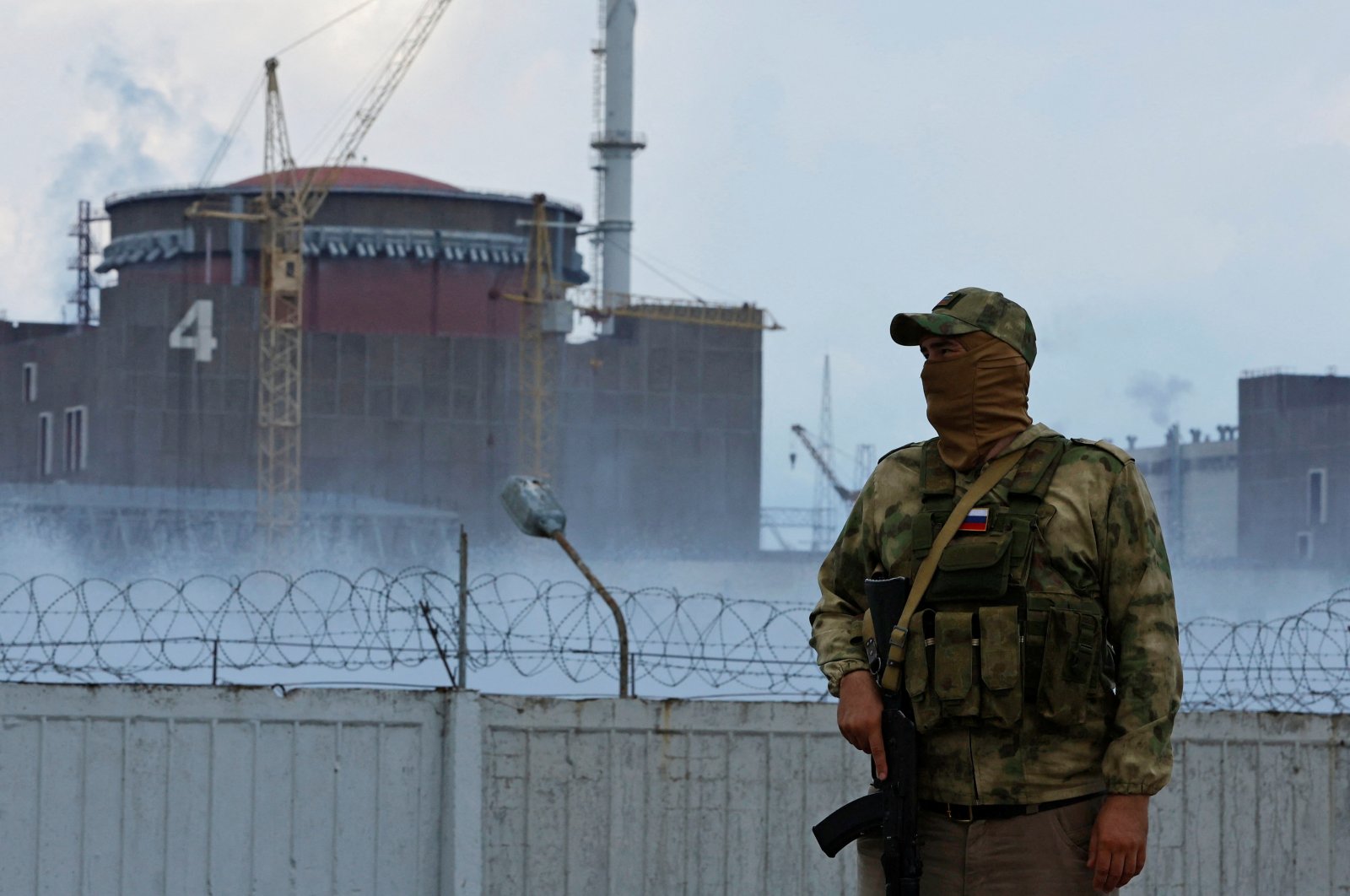 A serviceman with a Russian flag on his uniform stands guard near the Zaporizhzhia Nuclear Power Plant, Zaporizhzhia region, Ukraine, Aug. 4, 2022. (Reuters Photo)