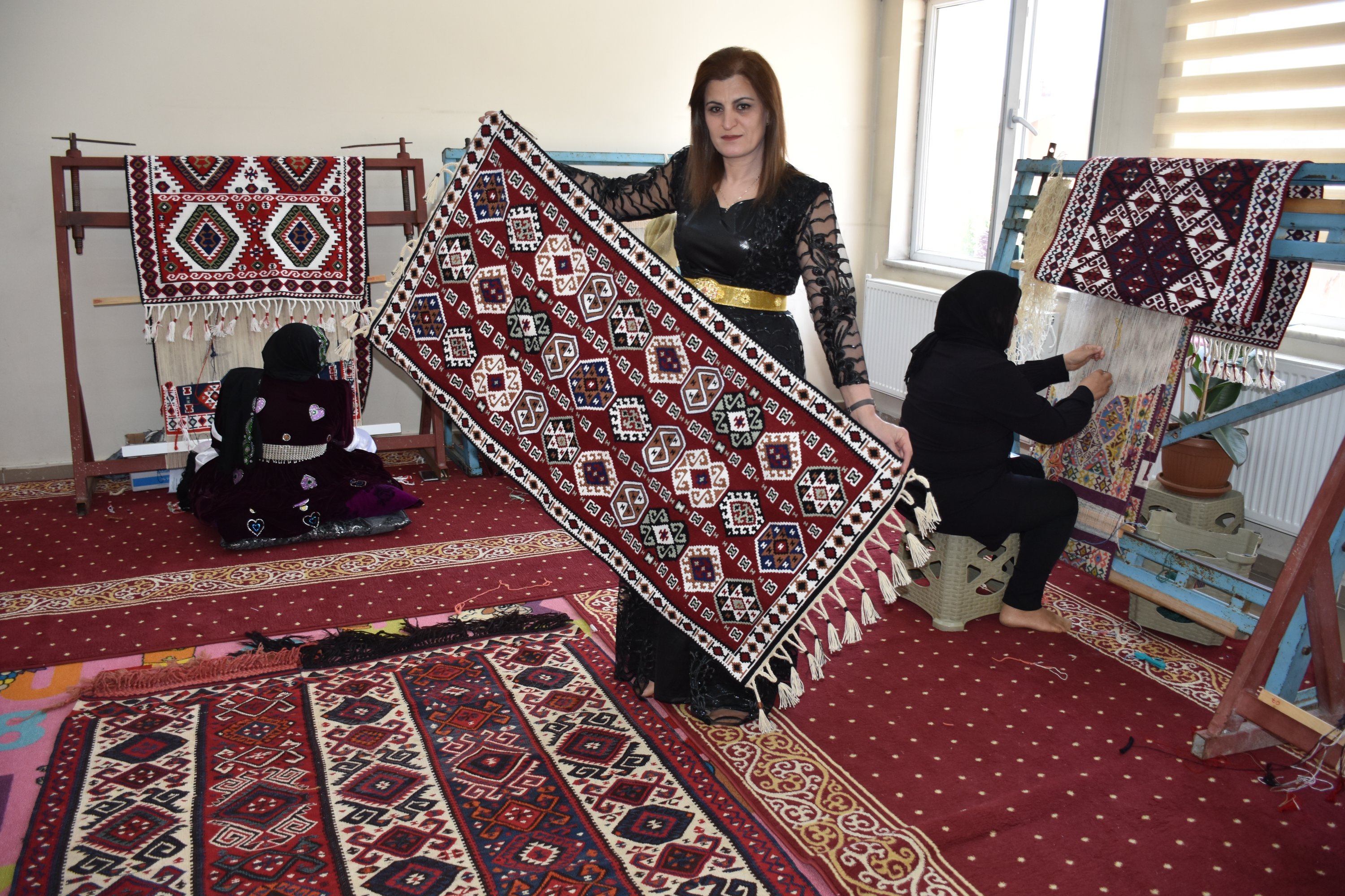 Seorang wanita menunjukkan kilim tradisional di Van Yüzüncü Yıl University Turkish Handicrafts Research and Application Center, Hakkari, tenggara Turki, 6 Agustus 2022. (AA Photo)