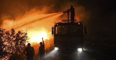 Firefighters pour water as they try to get the fire under control in Kirli village near the town of Manavgat, in Antalya province, Turkey, July 30, 2021. (AP Photo)