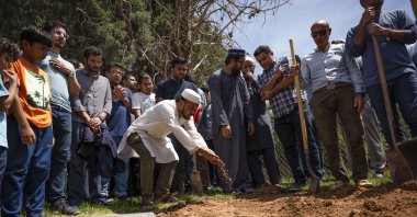 People sprinkle dirt over the grave of Muhammad Afzaal Hussain, 27, at Fairview Memorial Park in Albuquerque, New Mexico, U.S., Aug. 5, 2022. (Chancey Bush/The Albuquerque Journal via AP)