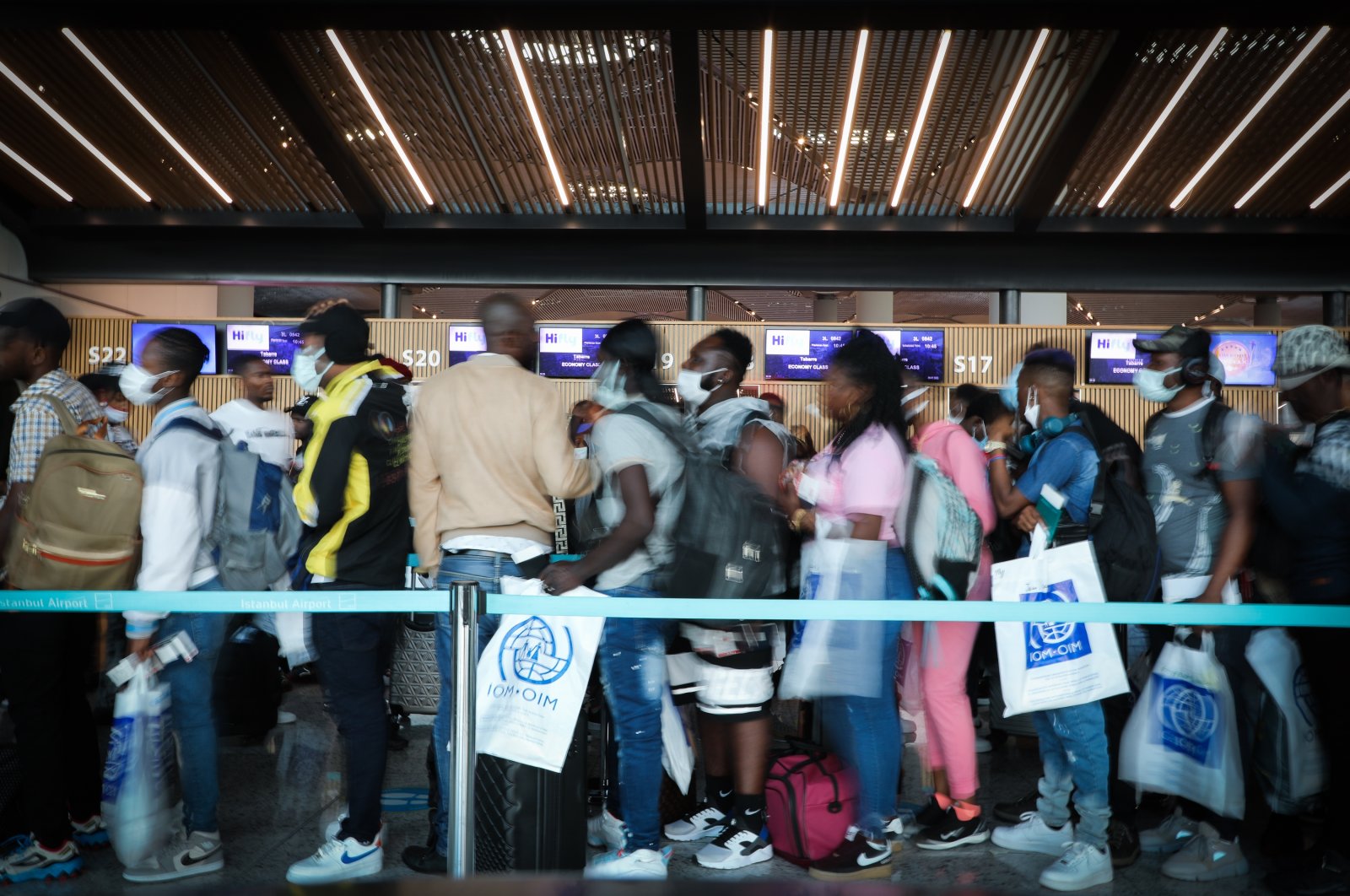 A group of Haitians are seen in a queue during the operation of the International Organization for Migration (IMO) at the Istanbul Airport, Turkey. (Courtesy of Emrah Özesen / the International Organization for Migration)