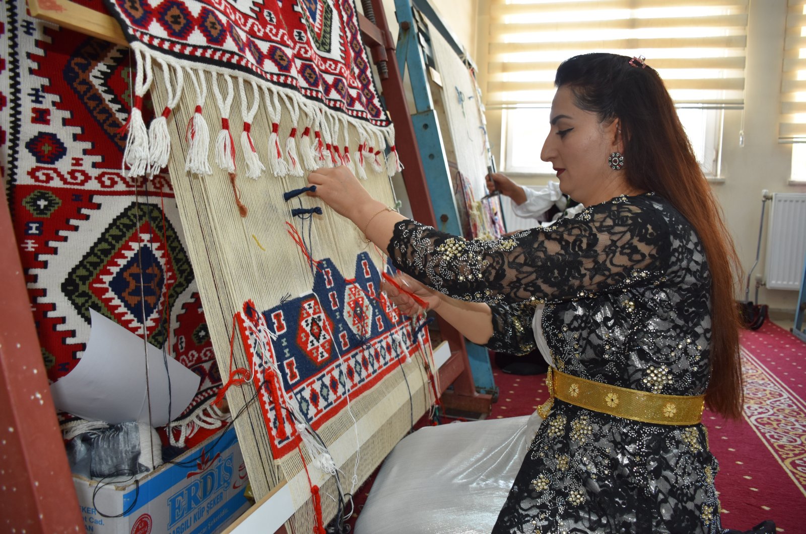 A woman weaves a traditional kilim at Van Yüzüncü Yıl University Turkish Handicrafts Research and Application Center, Hakkari, southeastern Turkey, Aug. 6, 2022. (AA Photo)