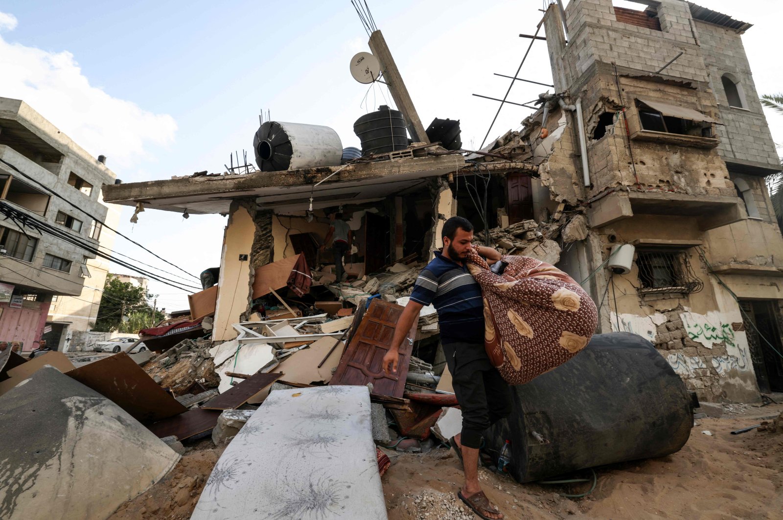 Warga Palestina melihat melalui puing-puing setelah serangan Israel terhadap Gaza