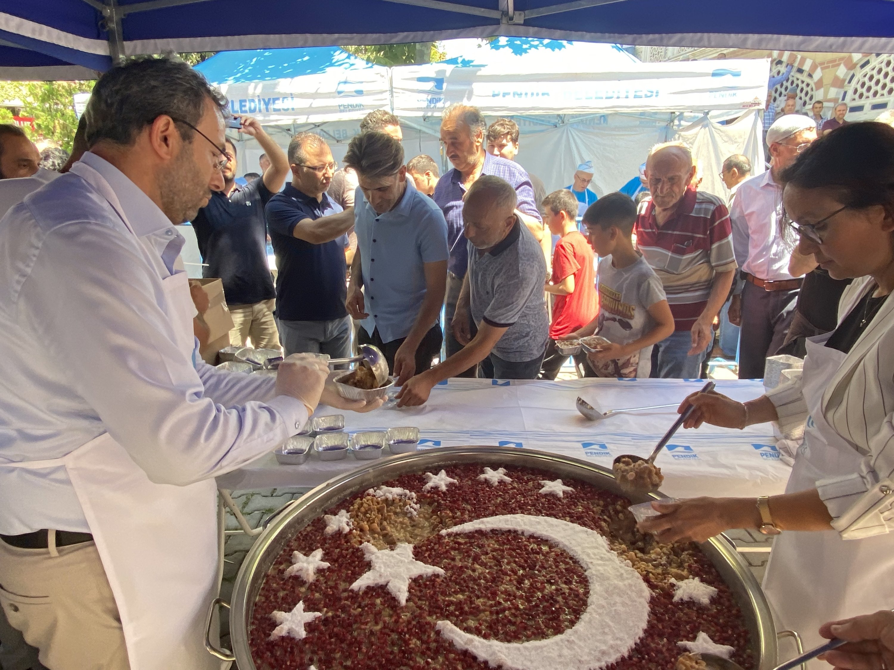 Orang-orang disuguhi makanan penutup tradisional ashura, di Pendik, di Istanbul, Turki, 8 Agustus 2022. (İHA PHOTO)