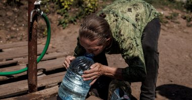 A local resident drinks clean water from a canister she just filled up, as Russia&#039;s attack on Ukraine continues, in Slovyansk, Ukraine, Aug. 7, 2022. (Reuters Photo)