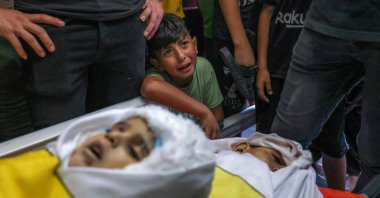 A boy cries by the bodies of four teenage Palestinians from the Najm family, during their funeral after they were killed during the latest three days of conflict between Israel and Palestinian group before a cease-fire, in Jabalia, the northern Gaza Strip, Palestine, Aug. 8, 2022. (AFP Photo)