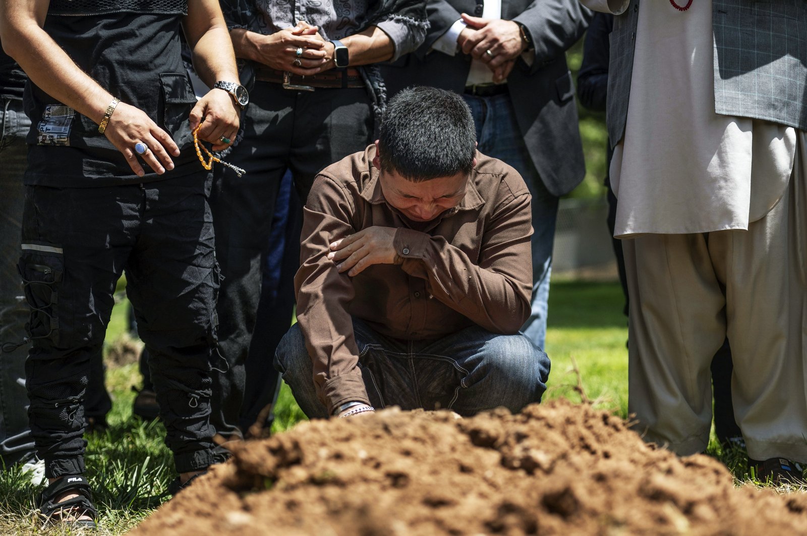 Altaf Hussain cries over the grave of his brother Aftab Hussein at Fairview Memorial Park in Albuquerque, N.M., on Friday, Aug. 5, 2022. (AP Photo)
