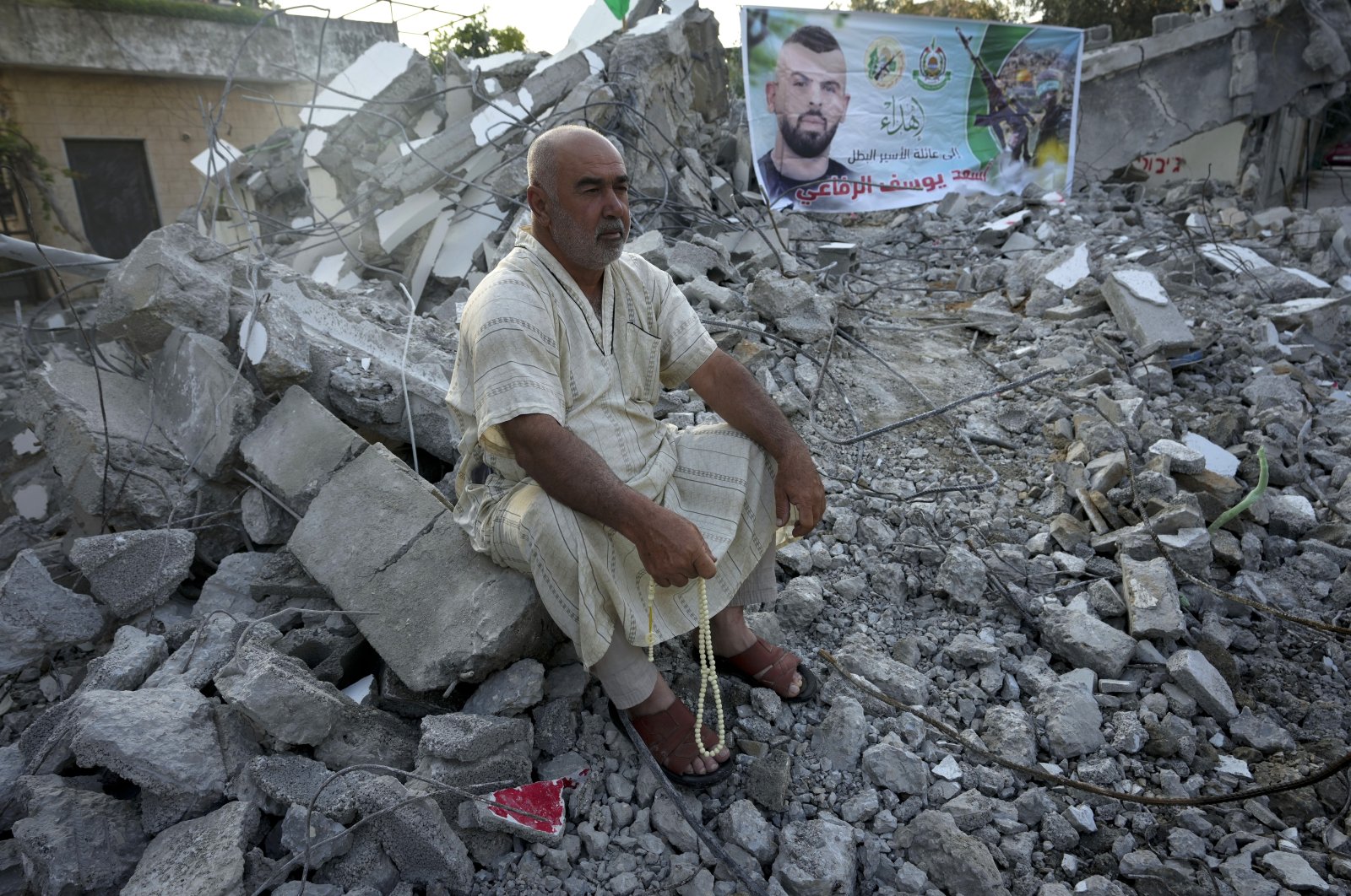 A Palestinian sits in the rubble of the house of Asad Rifai after it was demolished by Israeli forces along with the house of Subhi Sbeihat, both suspected of carrying out a deadly May 2022 attack on Israelis in the city of Elad, near Tel Aviv, in Rummana, near the occupied West Bank city of Jenin, Palestine, Aug. 8, 2022. (AP Photo)
