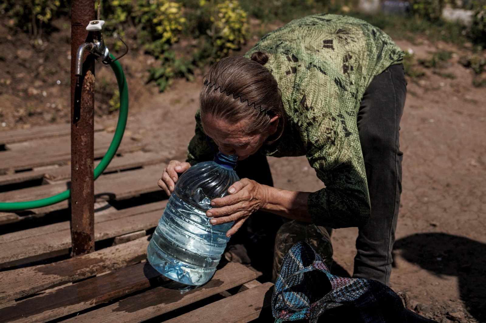 A local resident drinks clean water from a canister she just filled up, as Russia&#039;s attack on Ukraine continues, in Slovyansk, Ukraine, Aug. 7, 2022. (Reuters Photo)