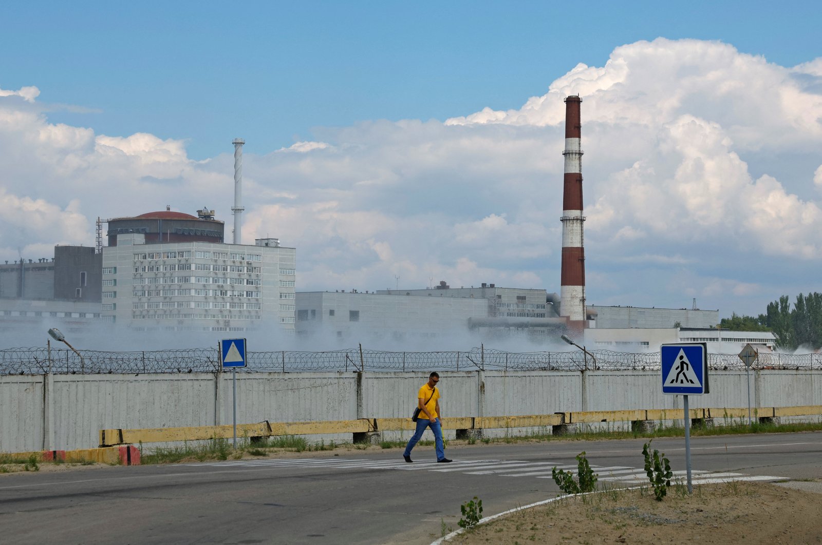 A man crosses a road near the Zaporizhzhia Nuclear Power Plant in the course of Ukraine-Russia conflict outside the Russian-controlled city of Enerhodar in the Zaporizhzhia region, Ukraine, Aug. 4, 2022. (Reuters Photo)