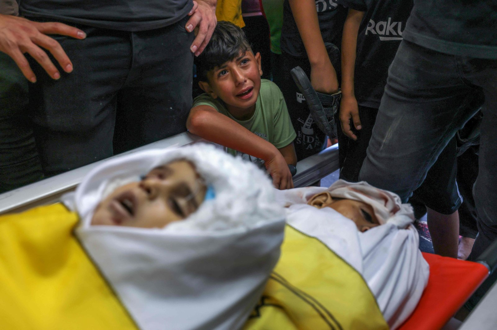 A boy cries by the bodies of four teenage Palestinians from the Najm family, during their funeral after they were killed during the latest three days of conflict between Israel and Palestinian group before a cease-fire, in Jabalia, the northern Gaza Strip, Palestine, Aug. 8, 2022. (AFP Photo)
