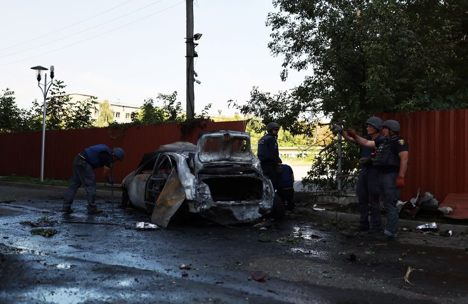 Police officers work next to a destroyed car after a Russian military strike, in Kharkiv, Ukraine, Aug. 8, 2022. (Reuters Photo)