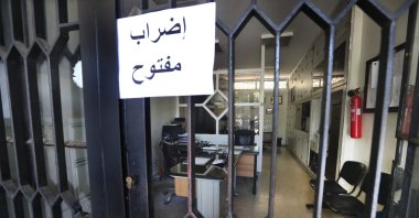 An Arabic placard reading &quot;Open strike&quot; is posted on a door of an empty municipality office, in Bramiyeh, south Lebanon, July 27, 2022. (AP Photo)