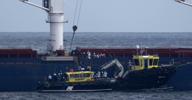 Russian, Ukrainian, Turkish and U.N. officials arrive at the cargo ship Razoni for inspection while it is anchored at the entrance of the Bosporus Strait in Istanbul, Türkiye, Wednesday, Aug. 3, 2022. (AP Photo)