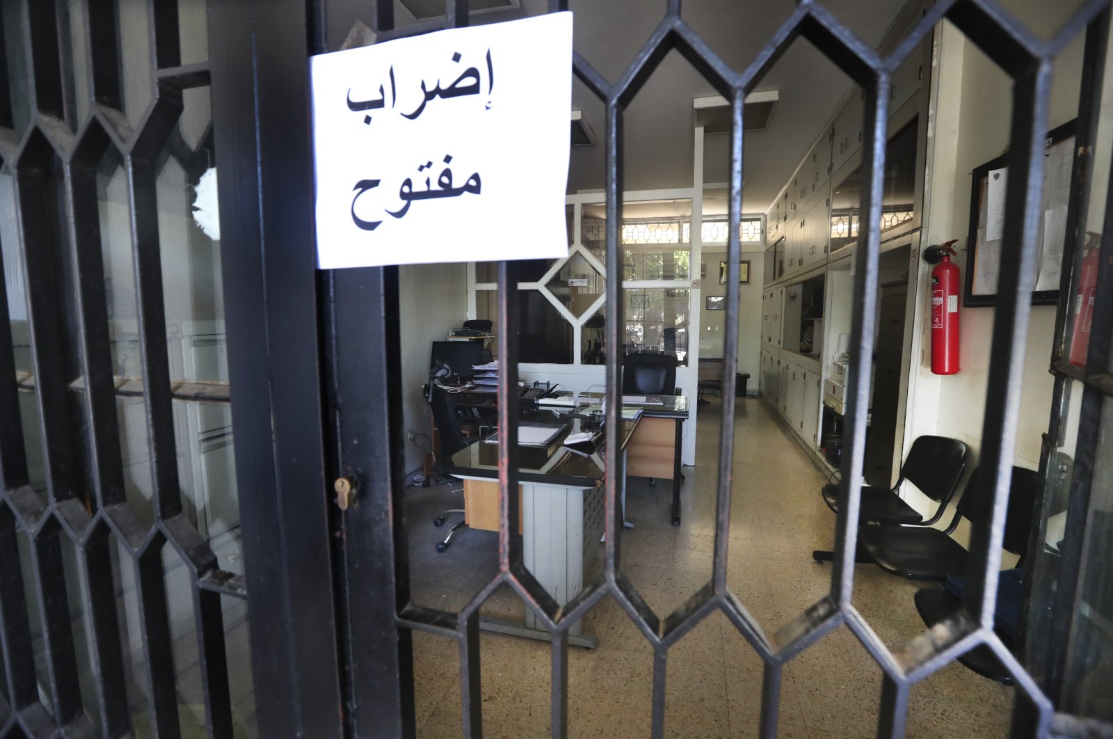 An Arabic placard reading &quot;Open strike&quot; is posted on a door of an empty municipality office, in Bramiyeh, south Lebanon, July 27, 2022. (AP Photo)