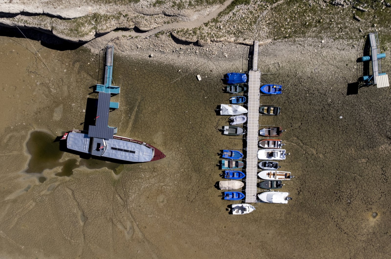 Boats are seen on the dried bed of the drought-affected Doubs River on the border with France in Les Brenets, Switzerland, Aug. 8, 2022. (Reuters Photo)