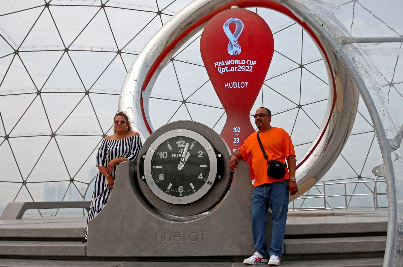 People pose for a picture with the Qatar 2022 FIFA World Cup countdown clock, Doha, Qatar, Aug. 10, 2022. (AFP Photo)