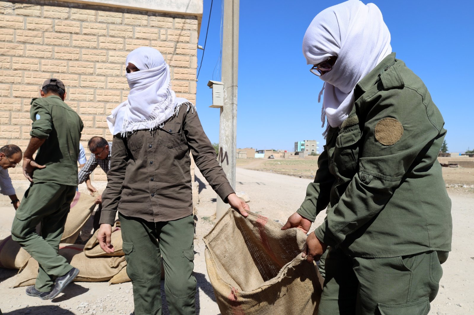 YPG/PKK terrorists fill a bag with dirt to build a position near their house at Amuda town of Hassakeh Governorate, close to the Syria-Türkiye border, northeastern Syria, July 28, 2022. (EPA Photo)