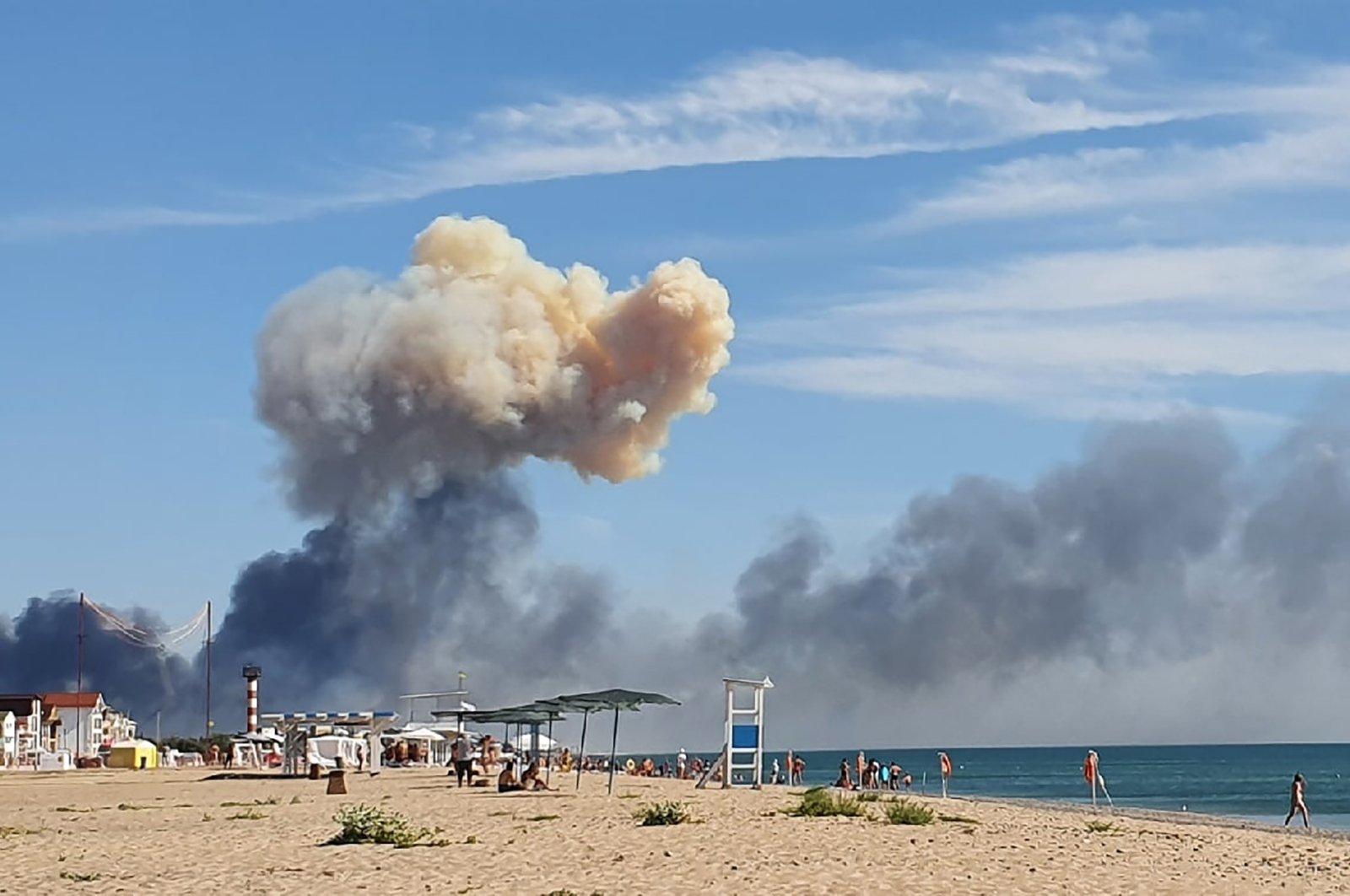 Rising smoke can be seen from the beach at Saky after explosions were heard from the direction of a Russian military airbase near Novofedorivka, Crimea, Ukraine, Aug. 9, 2022. (UGC via AP)