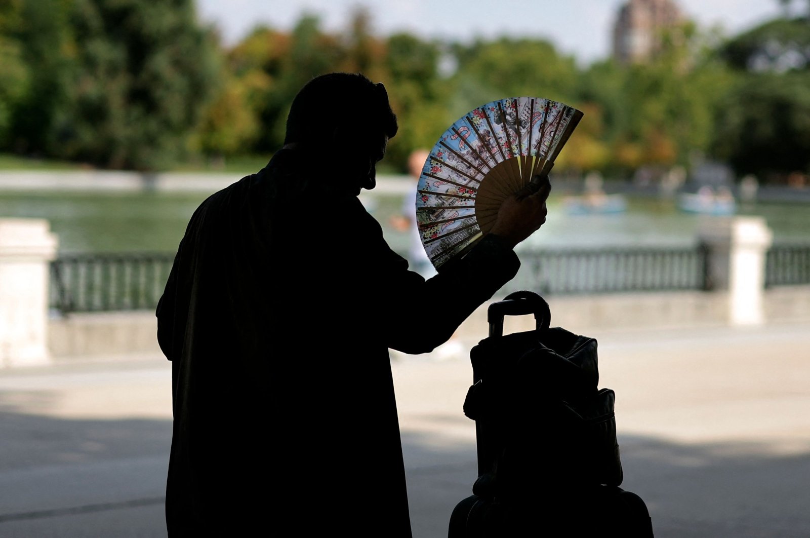 A man uses a hand fan in a park in central Madrid during a heatwave, Spain, Aug. 2, 2022. (AFP Photo)